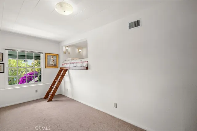 a bedroom with a bed lamp and a window
