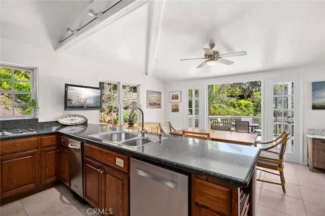 a kitchen with granite countertop a sink dining table and chairs