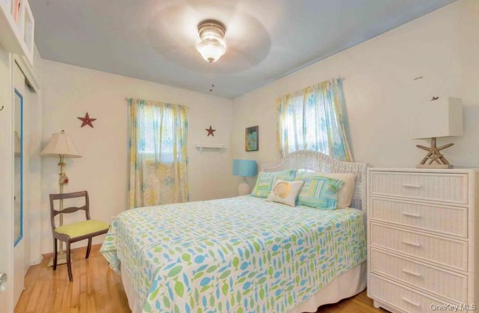 430 Grove Road Southold, NY 11971 - Photo 12 of 15 a bedroom with a bed and a chandelier