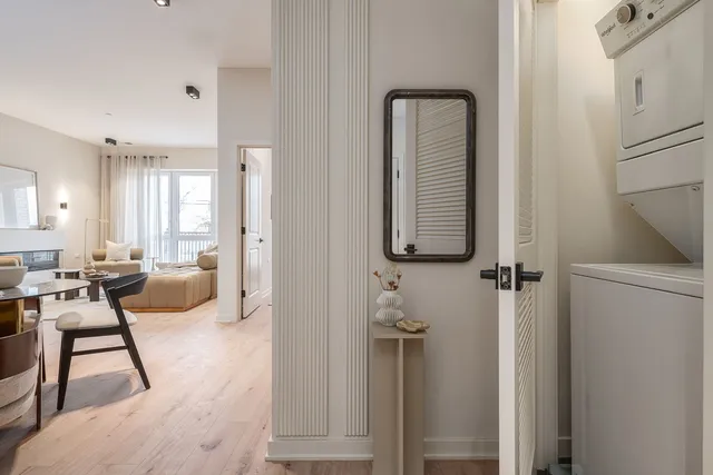 a room with lots of white furniture and wooden floor