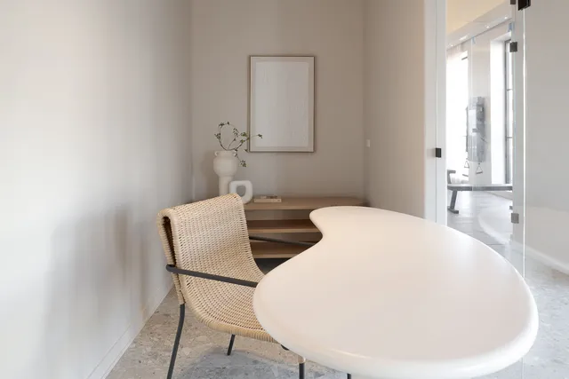 a view of a hallway with dining table and chairs