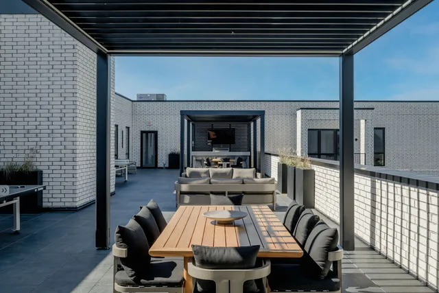 a roof deck with table and chairs and wooden floor