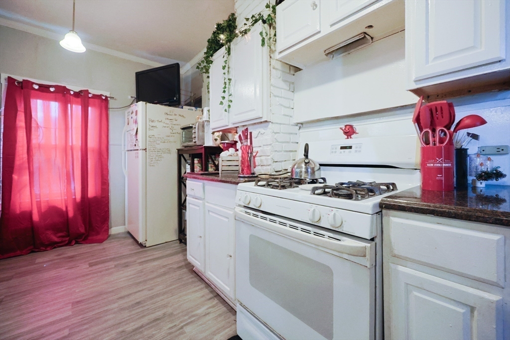 230 Pleasant Street Worcester, MA 01609 - Photo 16 of 23 a kitchen with granite countertop a stove top oven a sink and a refrigerator
