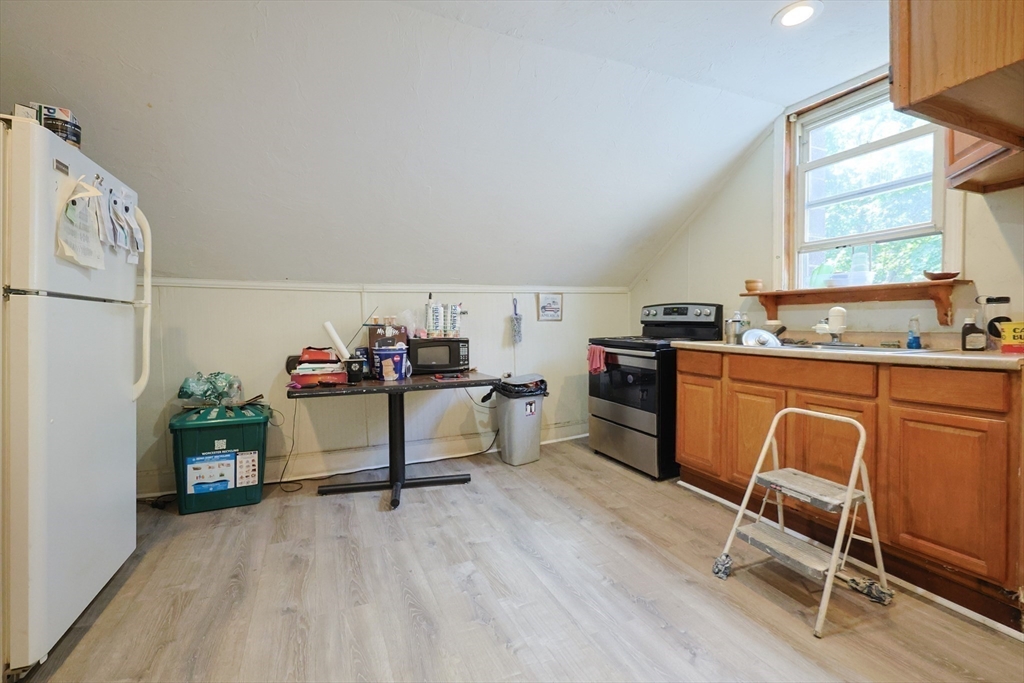 230 Pleasant Street Worcester, MA 01609 - Photo 22 of 23 a kitchen with a table chairs refrigerator and a sink