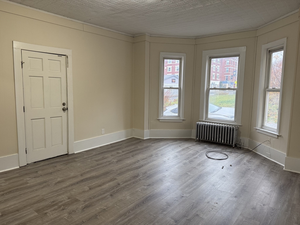 230 Pleasant Street Worcester, MA 01609 - Photo 5 of 23 an empty room with wooden floor and windows