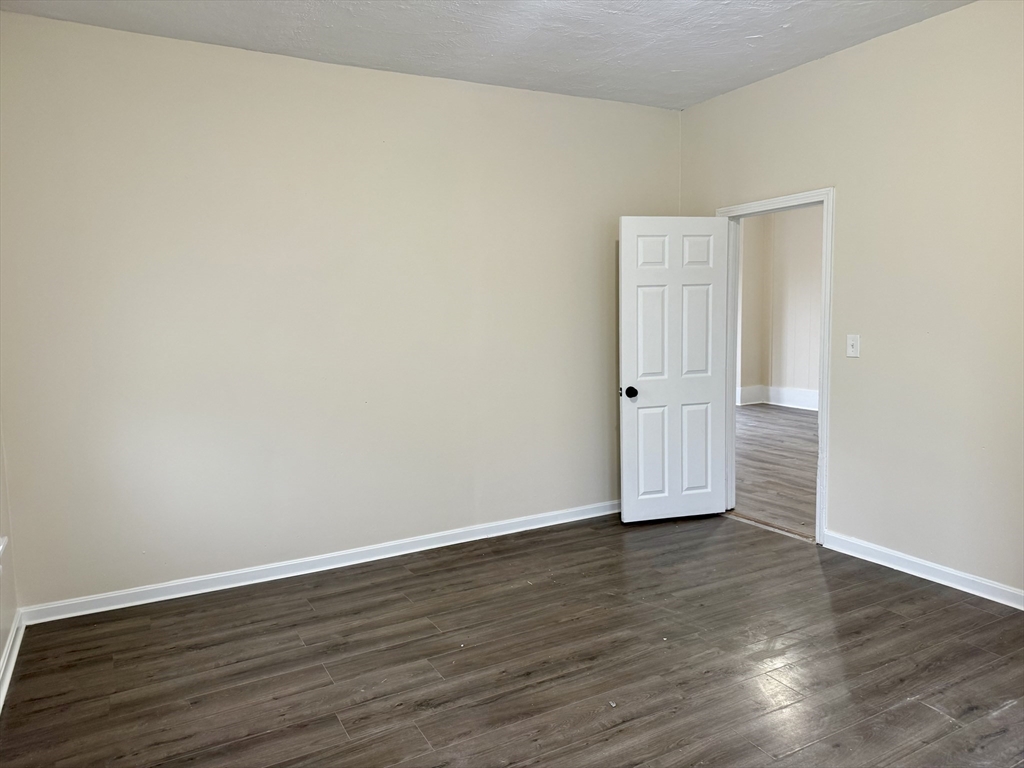 230 Pleasant Street Worcester, MA 01609 - Photo 6 of 23 an empty room with wooden floor