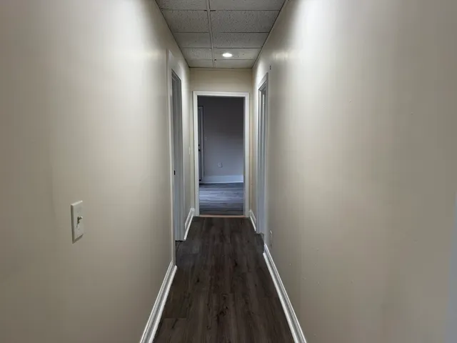 a view of a hallway with wooden floor and staircase
