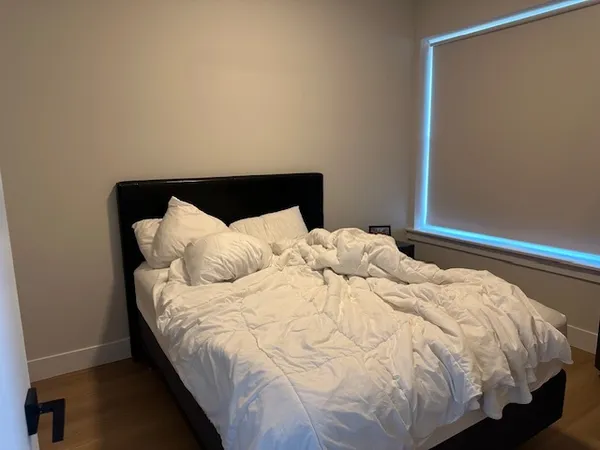 a bed sitting in a bedroom next to a window