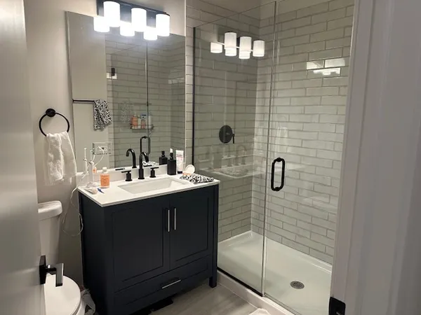 a bathroom with a sink mirror and shower