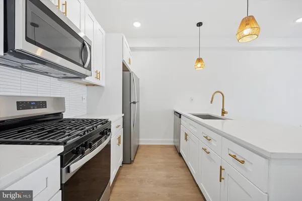 a kitchen with stainless steel appliances granite countertop a sink and a stove