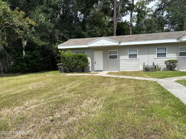a view of a house with a yard and tree
