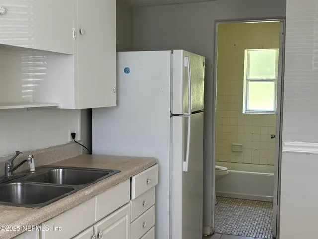 a kitchen with a refrigerator sink and cabinets
