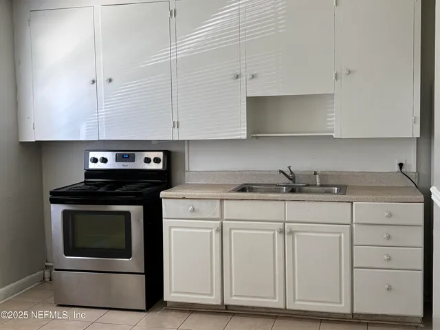 a kitchen with granite countertop white cabinets and stainless steel appliances