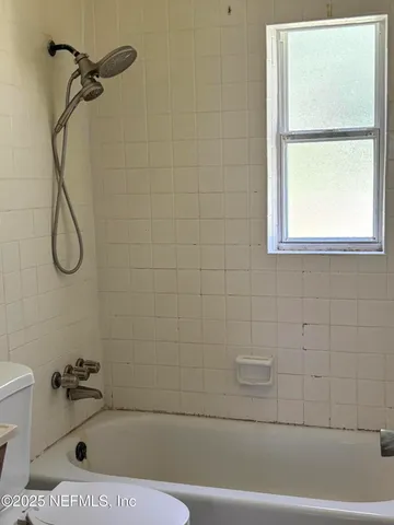 a bathroom with a bath tub with a shower