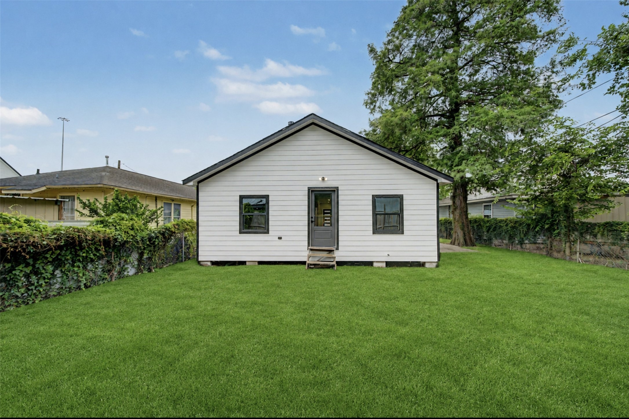 2338 Lidstone Street Houston, TX 77023 - Photo 16 of 17 (Photoshop)Fresh white exterior and black trim, set on a spacious yard. Ideal for outdoor activities and gardening.
