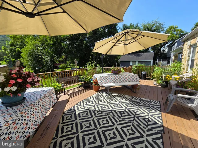 a patio with tables and chairs under an umbrella