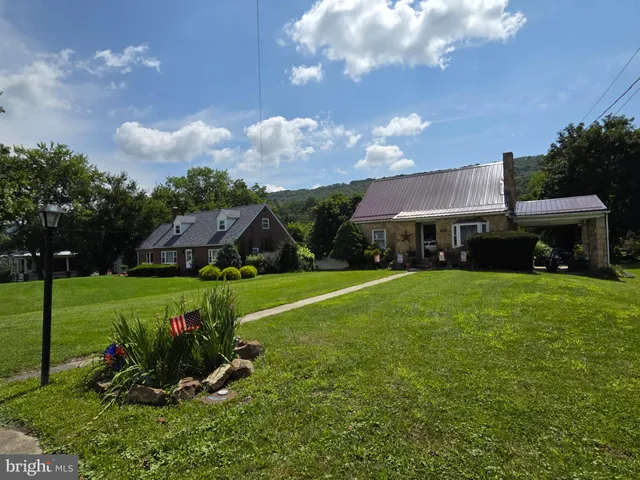 a front view of a house with garden and a yard
