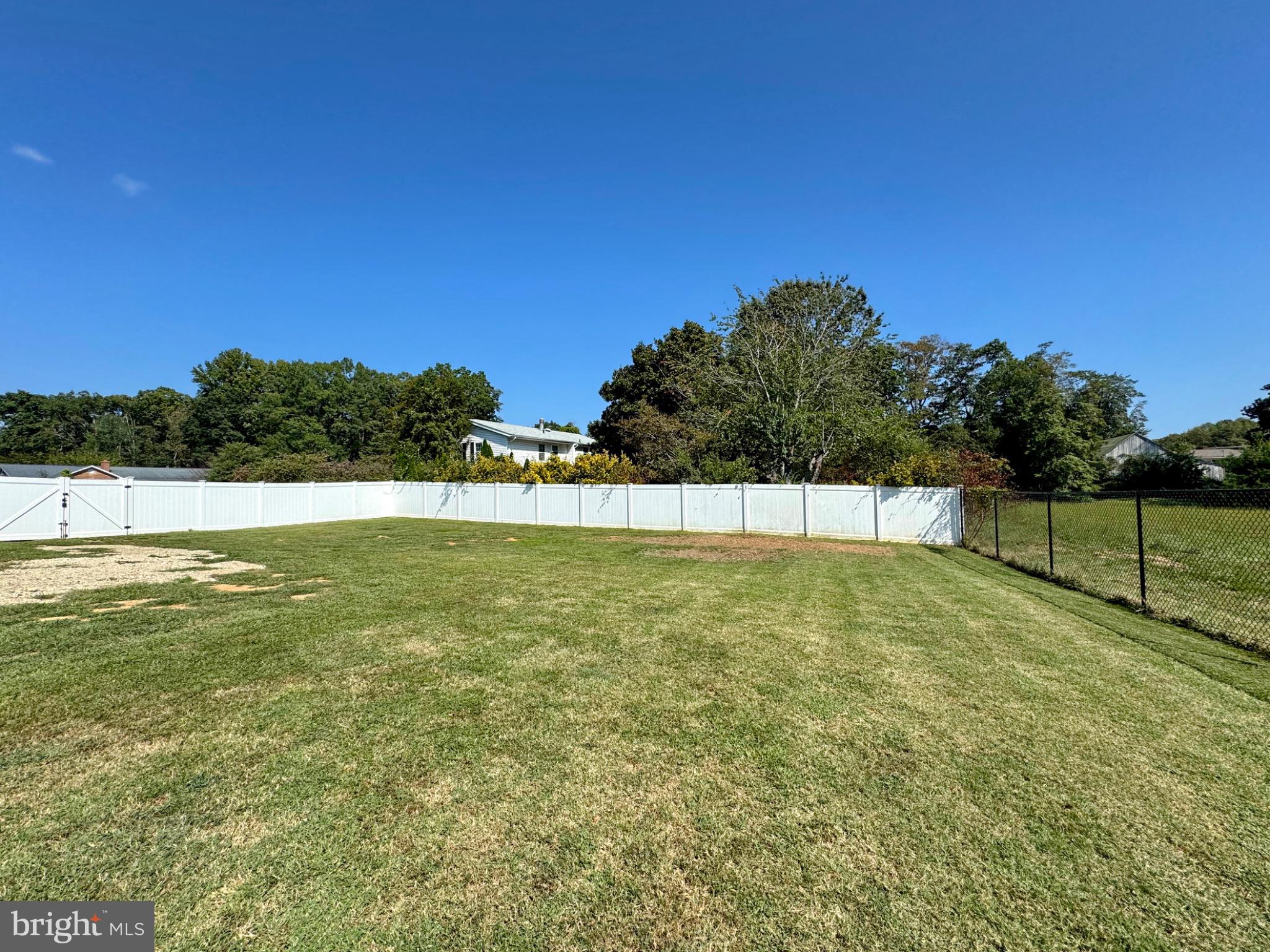 7406 Robin Road La Plata, MD 20646 - Photo 75 of 89 Spacious fenced yard under a clear blue sky.