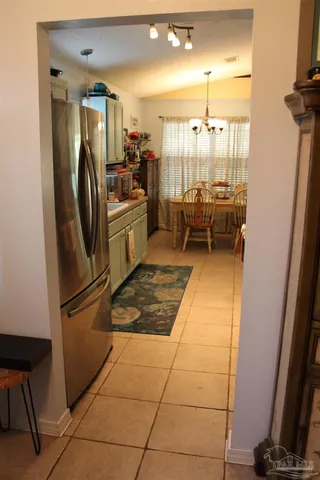 a kitchen with a refrigerator and white cabinets