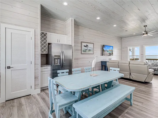 a view of a dining room with furniture a rug and wooden floor