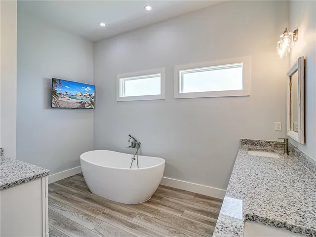 a spacious bathroom with a granite countertop sink and a mirror