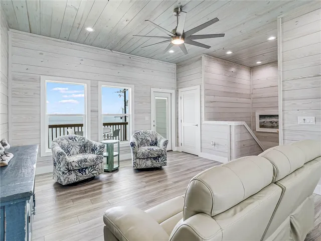 a living room with furniture ceiling fan and a wooden floor