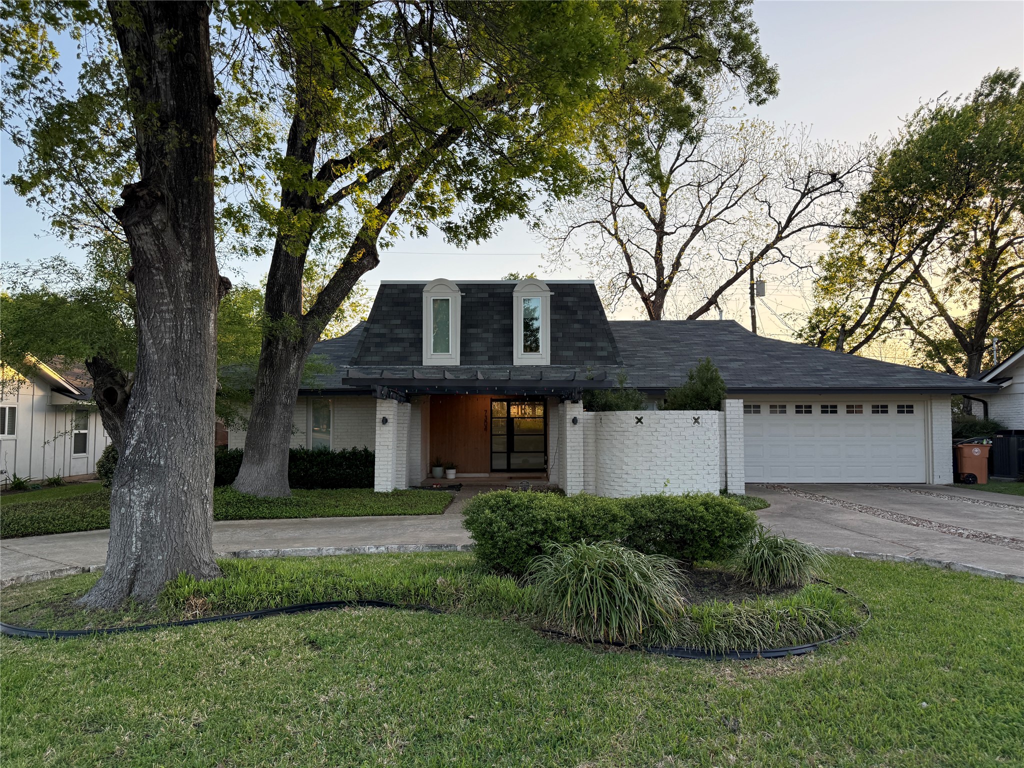 7304 Geneva Drive Austin, TX 78723 - Photo 1 of 39 a front view of a house with a garden