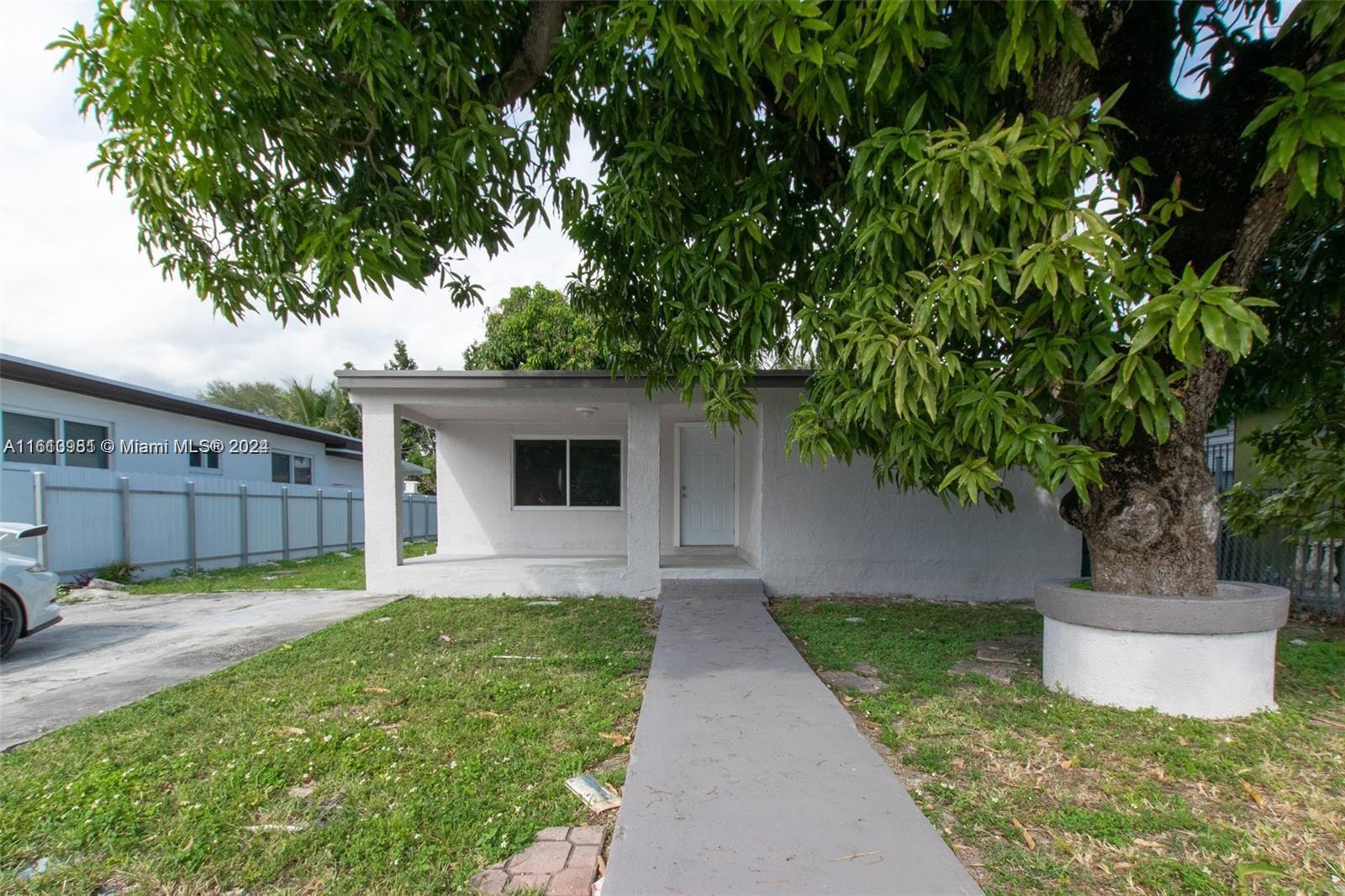 1113 Northwest 103rd Street, Unit 1 Miami, FL 33150 - Photo 1 of 12 a front view of a house with garden