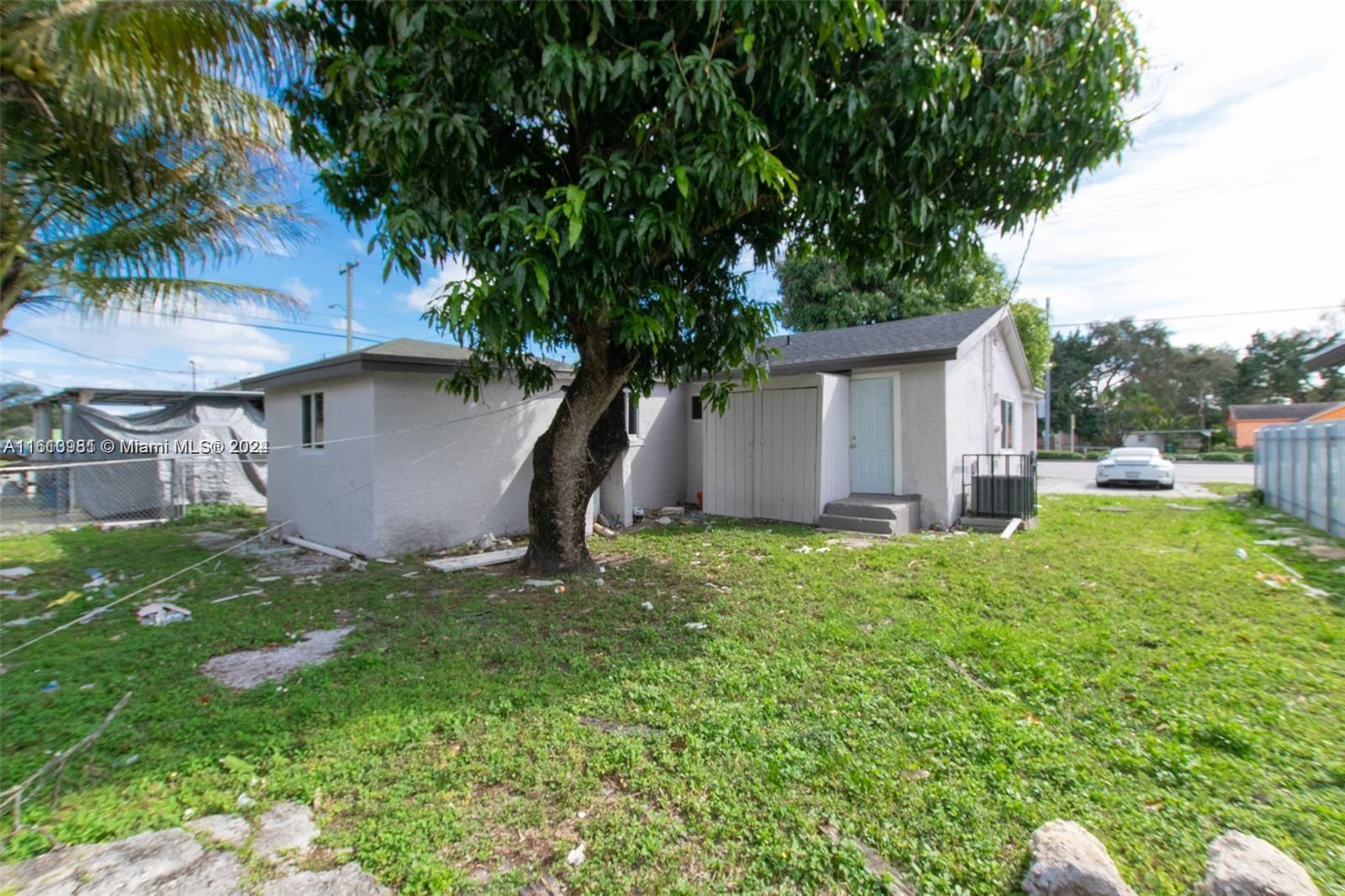 1113 Northwest 103rd Street, Unit 1 Miami, FL 33150 - Photo 12 of 12 a backyard of a house with plants and tree