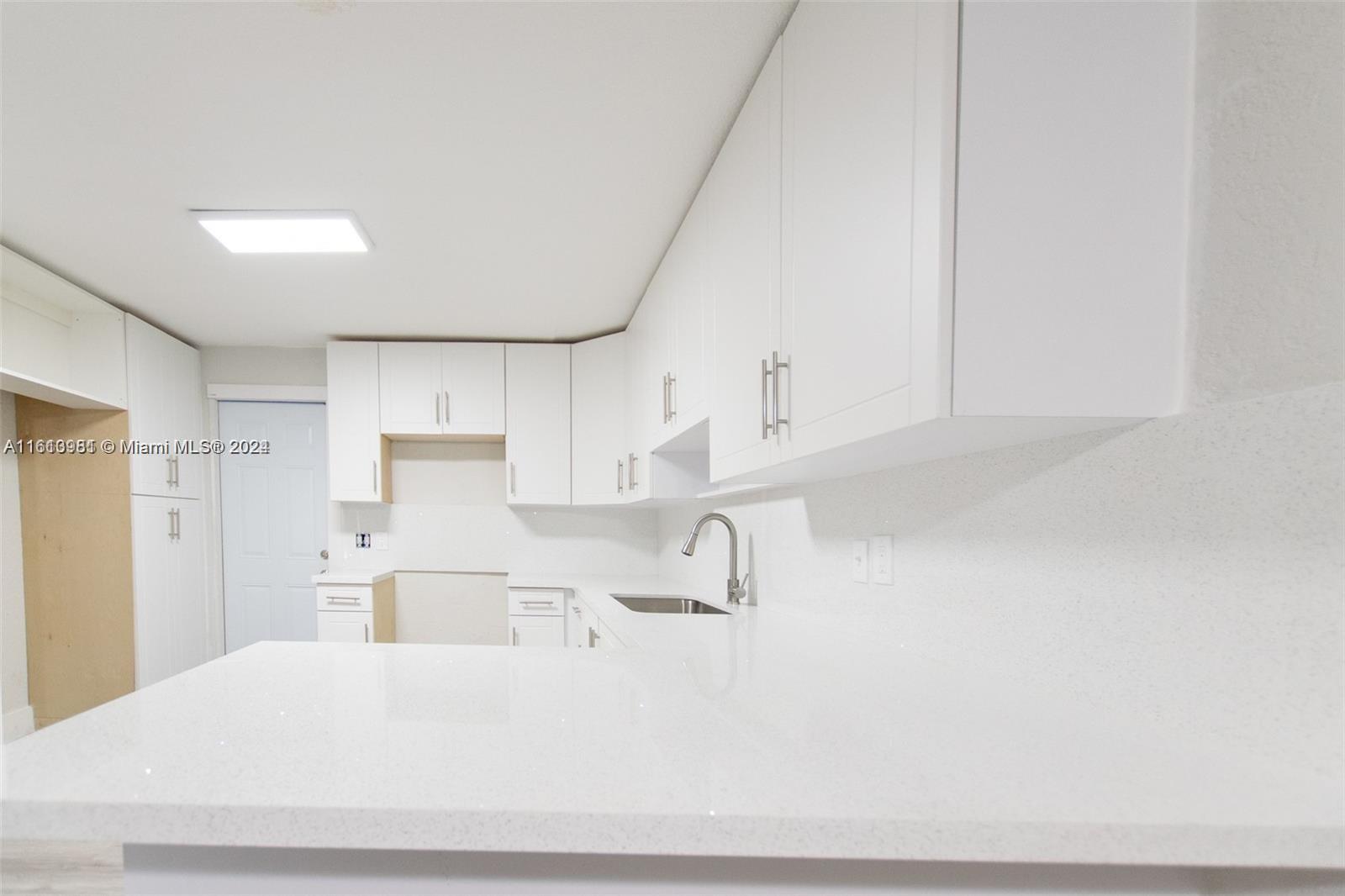 1113 Northwest 103rd Street, Unit 1 Miami, FL 33150 - Photo 7 of 12 a view of kitchen with white cabinets