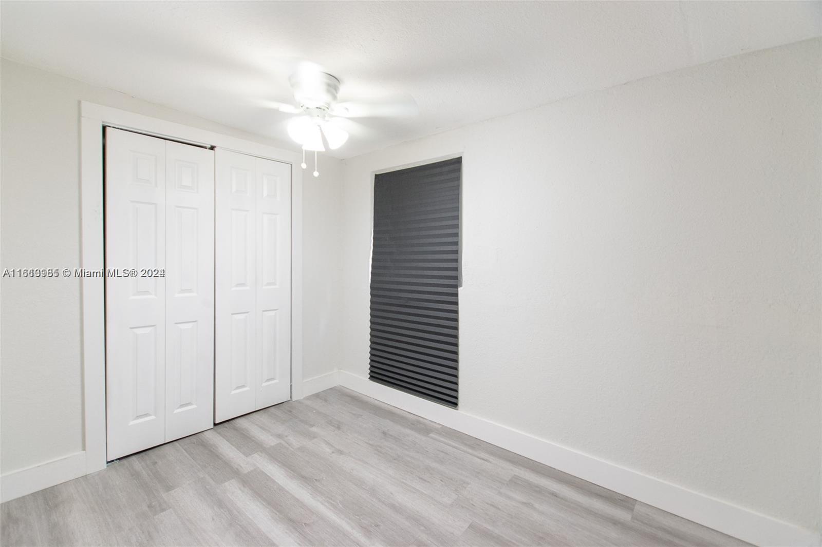 1113 Northwest 103rd Street, Unit 1 Miami, FL 33150 - Photo 10 of 12 a view of an empty room with a ceiling fan