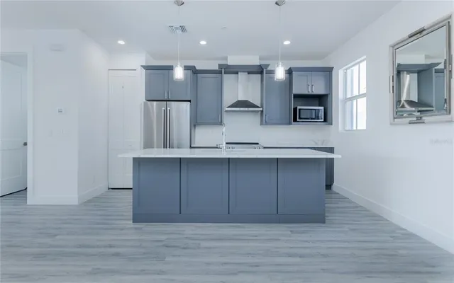 a view of kitchen with granite countertop cabinets and refrigerator
