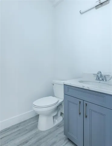 a bathroom with a granite countertop toilet and a sink