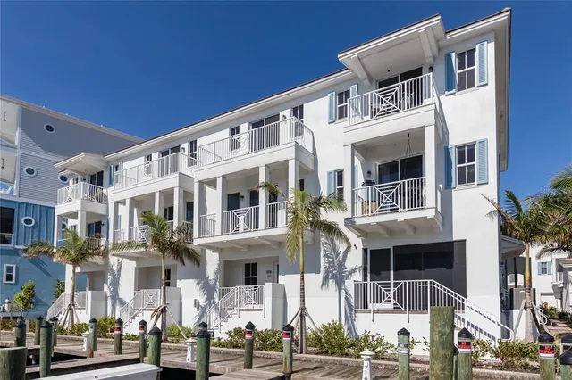 a front view of a building with glass windows and plants