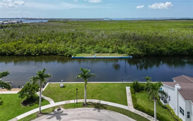 an aerial view of a house with a yard and lake view