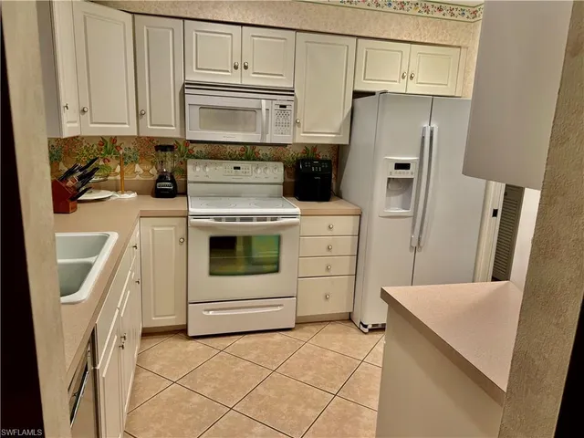 a kitchen with stainless steel appliances a refrigerator sink and cabinets
