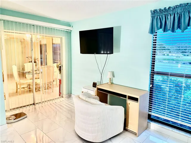 a living room with a flat screen tv and a floor to ceiling window