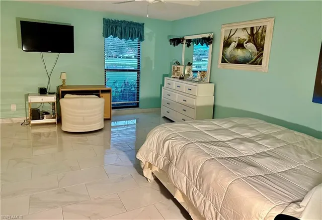 a bedroom with a bed and flat screen tv