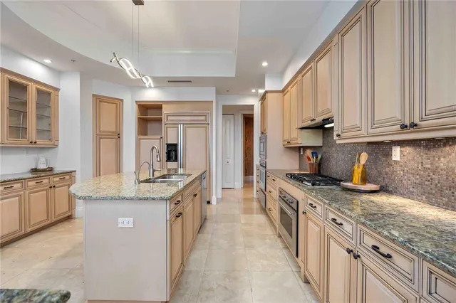 a kitchen with stainless steel appliances granite countertop a stove top oven a sink dishwasher and cabinets with wooden floor