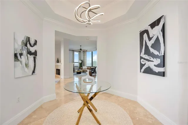 a dining room with wooden floor and chandelier