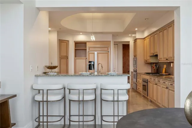 a kitchen with stainless steel appliances granite countertop a stove a sink and a refrigerator