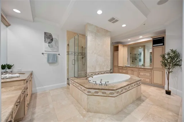a bathroom with a granite countertop tub sink and mirror