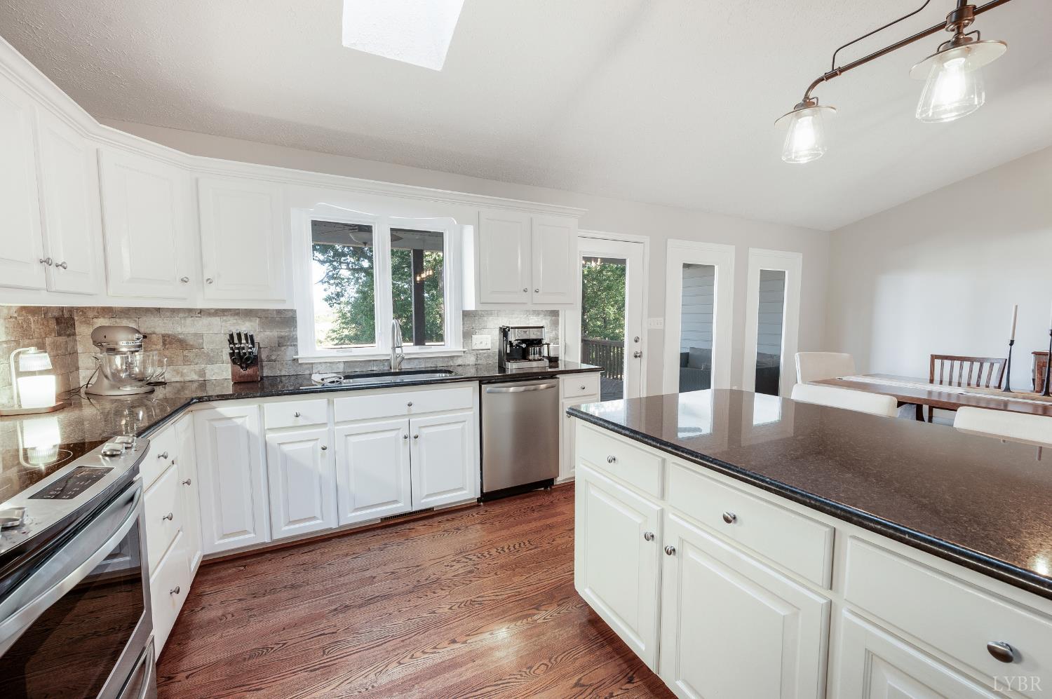 1203 Everett Road Forest, VA 24551 - Photo 16 of 68 a kitchen with granite countertop white cabinets white appliances a sink and a window