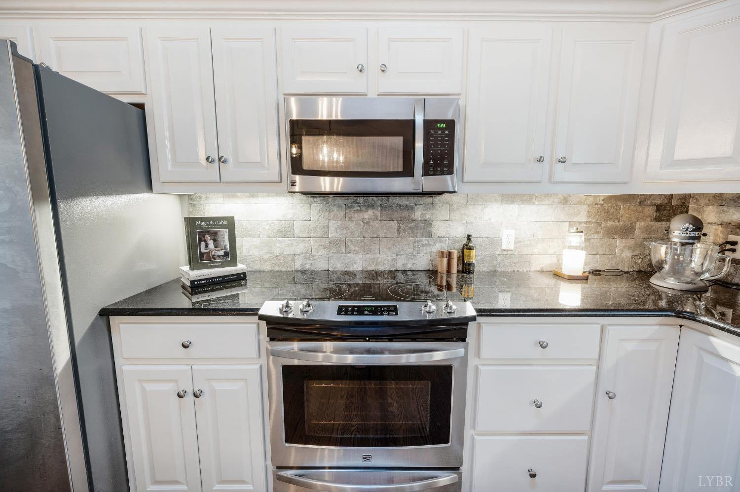 1203 Everett Road Forest, VA 24551 - Photo 17 of 68 a kitchen with granite countertop white cabinets and stainless steel appliances