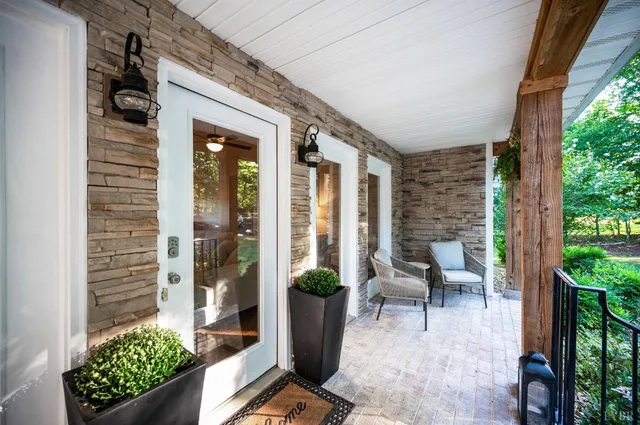 a view of a porch with chairs and potted plants