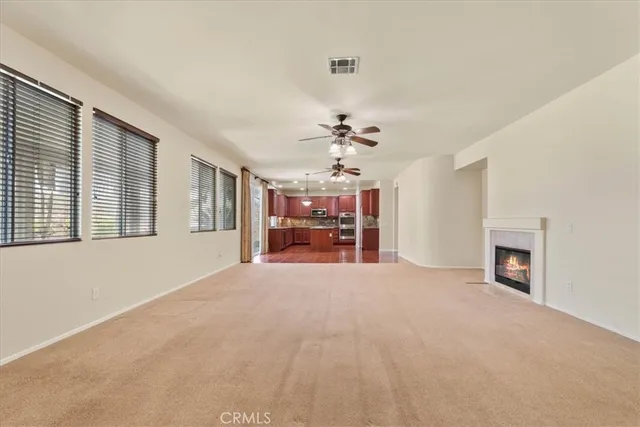 a view of a livingroom with a fireplace a chandelier and windows