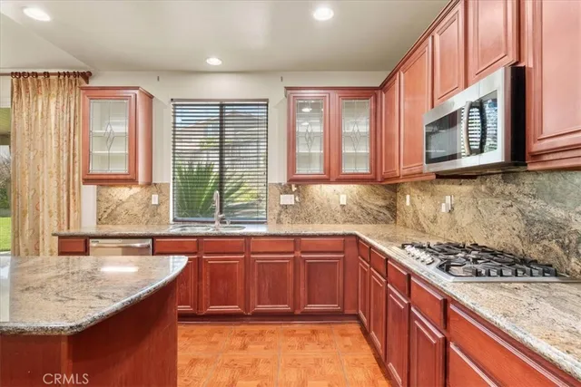 a kitchen with stainless steel appliances granite countertop a sink stove and cabinets