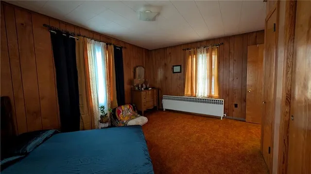 an empty room with window and hardwood