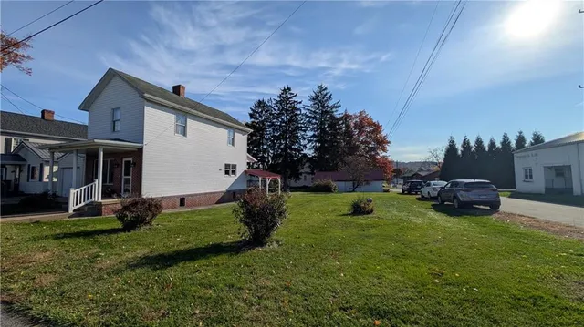 a view of a house with backyard and sitting area
