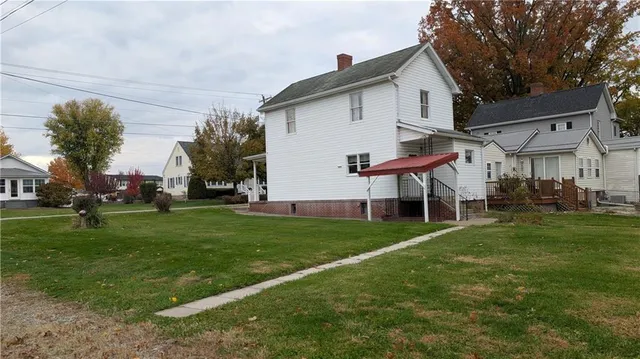 a view of a house with a big yard and a large tree